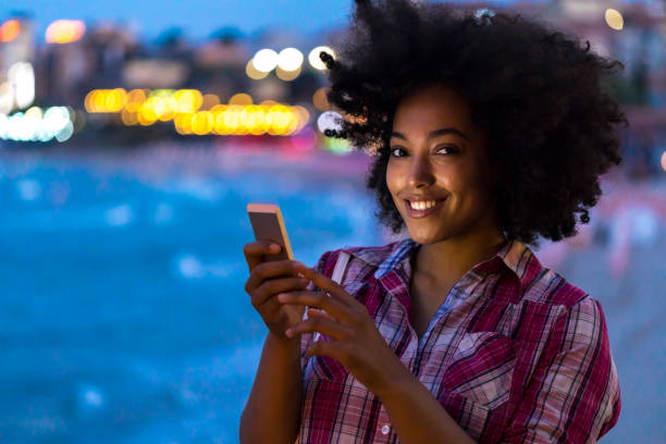 istock Woman using smart phone on street at night 940586384