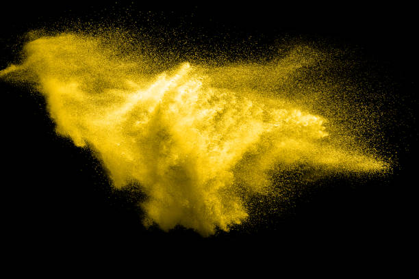 istock abstract yellow dust explosion on  black background. abstract yellow powder splatter on dark background. Freeze motion of yellow powder splashing. 940587672