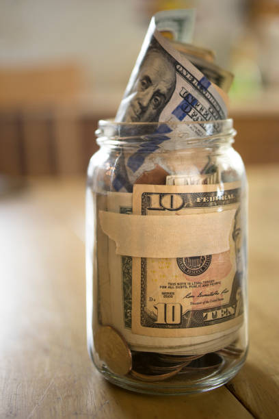 istock Glass Jar Filled with U.S. Currency 940590784