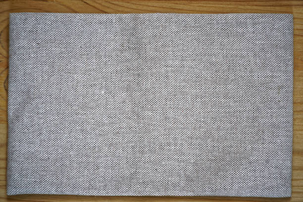 istock Linen fabric surface on wooden table for mock-up or designer use, book cover sample 940593486
