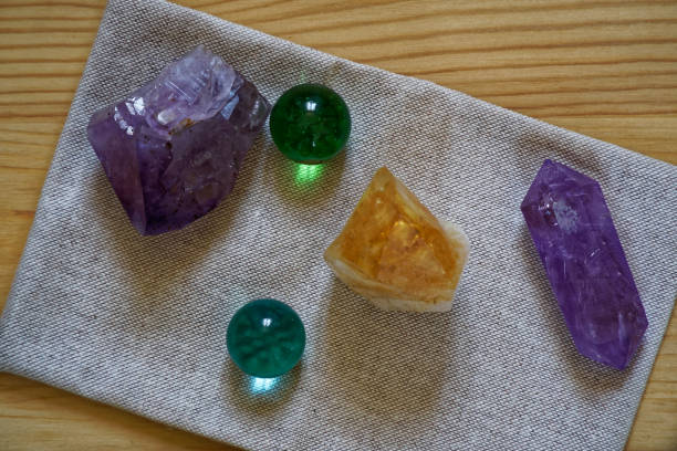 istock Crystals on linen fabric surface, mock-up for postcard or background for website and mobile devices Gems colored in royal purple, autumn maple and golden lime colors 940594464
