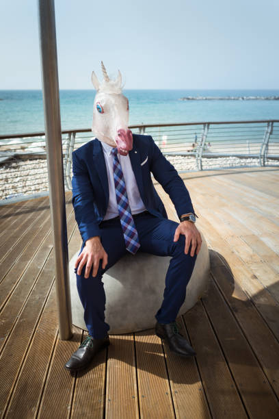 istock Strange guy in elegant suit sits on the city waterfront 940598542