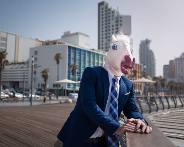 istock Unusual young man in elegant suit stands on the city waterfront 940598564