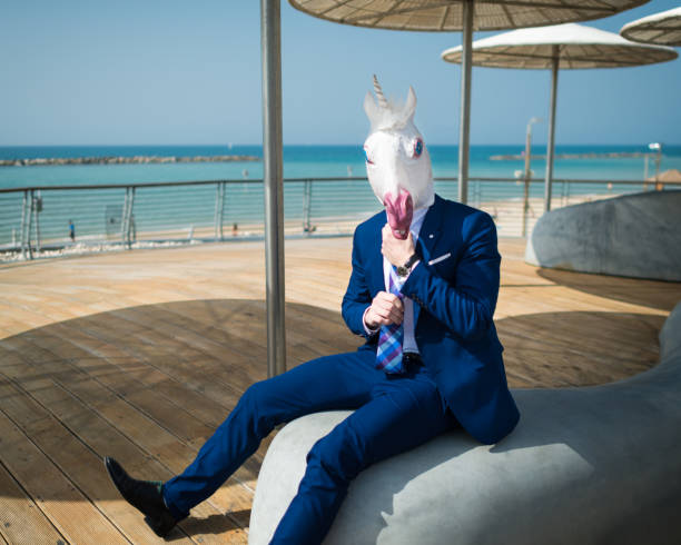 istock Young man is dressed up a suit under stylish umbrellas on the city waterfront 940598662