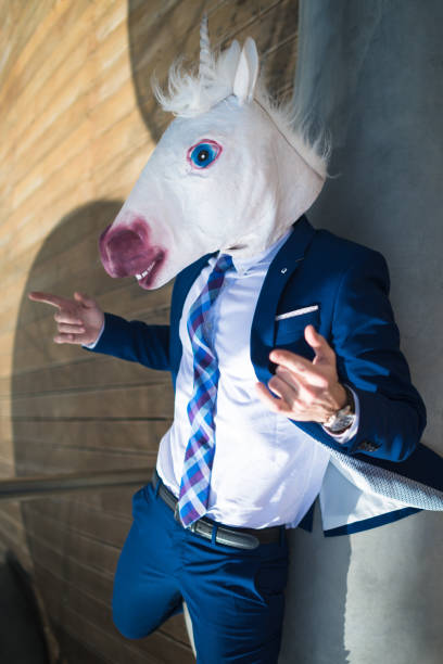 istock Young successful manager in elegant suit and funny mask active gesticulate 940598664
