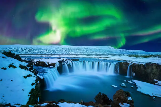 Photo of Northern Light, Aurora borealis at Godafoss waterfall in winter Iceland.