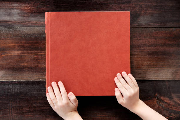 istock kid holding hands on brown leather covered wedding album or book 940603018