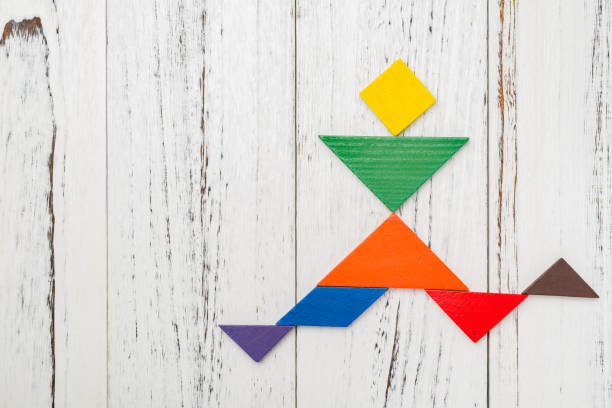 istock wooden tangram shaped like a people running and  jumpping with copy space 940607320