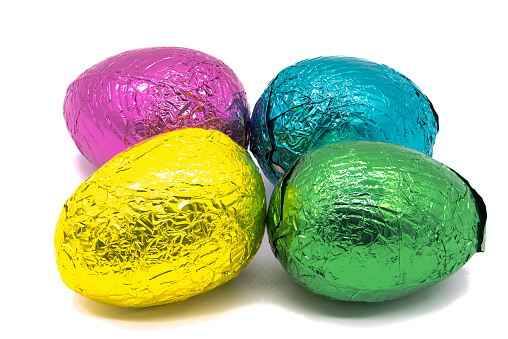 Four Colourful Foil Wrapped Easter Eggs on a plain white background