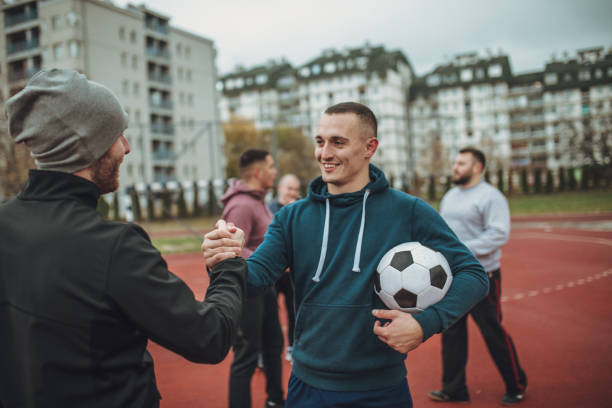 istock Friends standing on a soccer playing field and handshake 940618888