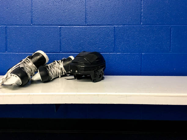 Hockey skates and helmet in white bench in locker room with copy space ice Sport skates and helmet in locker room with blue background hockey skates stock pictures, royalty-free photos & images
