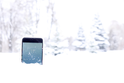 mobile phone lie in snow in forest and on the screen how many degrees outside in winter time