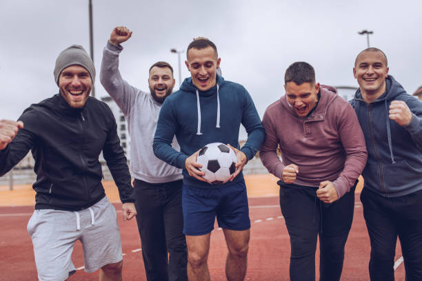 istock Group of men celebrating victory on a soccer playing field 940632264