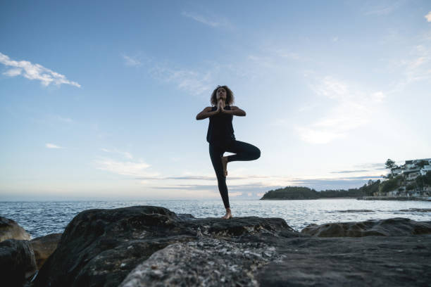 istock Woman doing yoga exercises at the beach 940636568