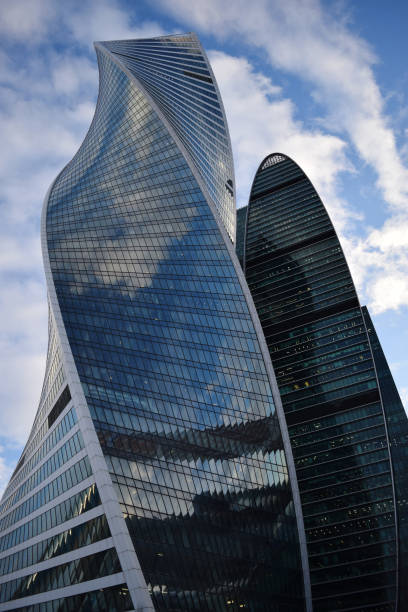 istock Low angle view of skyscrapers against cloudy sky 940639910