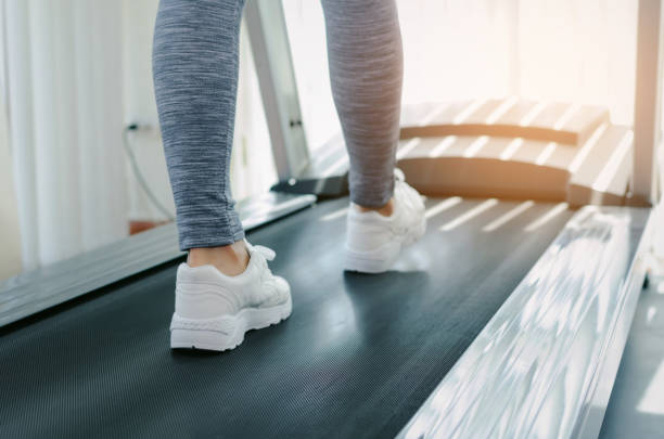 motion of runner woman feet running on machine treadmill at fitness gym center or health club with sunlight effect, bodybuilder, healthy lifestyle, exercise fitness, workout and sport training concept movimiento de pies de mujer corredor corriendo en cinta rodante de la máquina en el gimnasio centro o salud gimnasio con efecto de luz del sol, culturista, estilo de vida saludable, ejercicio fitness, entrenamiento y deporte entrenamiento concepto