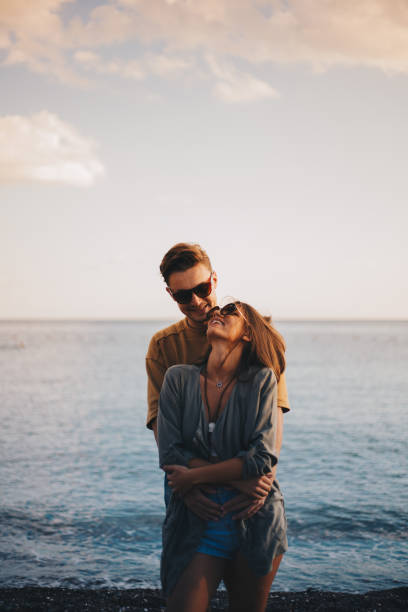 istock Millennial couple enjoying spring picnic by the beach 940674076