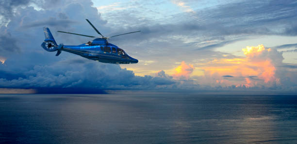 Helicopter in Front of a Thunderstorm Over the Atlantic Ocean at Sunrise A helicopter flies by as Thunderstorms build over the Atlantic Ocean at sunrise in Palm Beach, Florida helicopter modern stock pictures, royalty-free photos & images