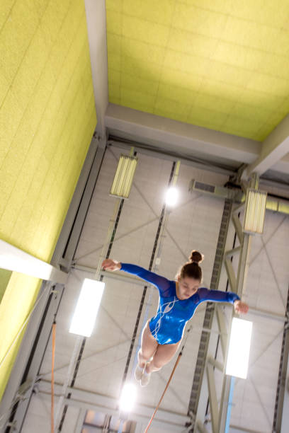 istock Low Angle View of Gymnastics Athlete Jumping on Trampoline 940682718