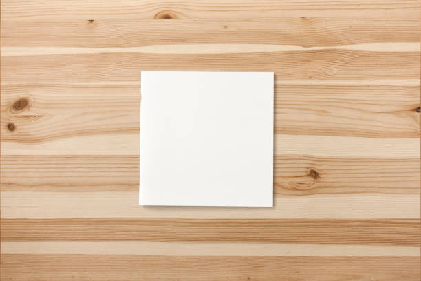 istock Square Magazine with blank soft cover on wooden background. 3d illustration. 940693508