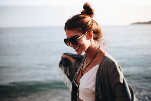 istock Millennial girl with blanket  by the beach 940694132