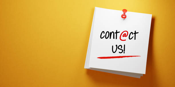 istock White Sticky Note With Contact Us Message and Red Push Pin On Yellow Background 940700294