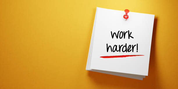 istock White Sticky Note With Work Harder Message and Red Push Pin On Yellow Background 940700478