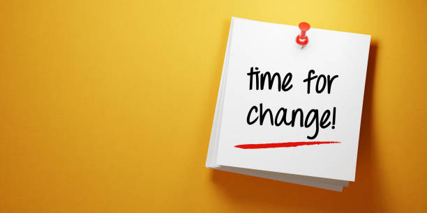 istock White Sticky Note With Time For Change Message and Red Push Pin On Yellow Background 940701164