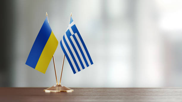 istock Ukrainian And Greek Flag Pair On A Desk Over Defocused Background 940709144