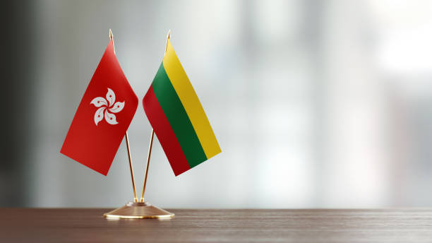 istock Hong Kong And Lithuanian Flag Pair On A Desk Over Defocused Background 940709582