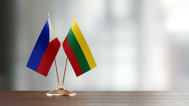 istock Philippines And Lithuanian Flag Pair On A Desk Over Defocused Background 940712106