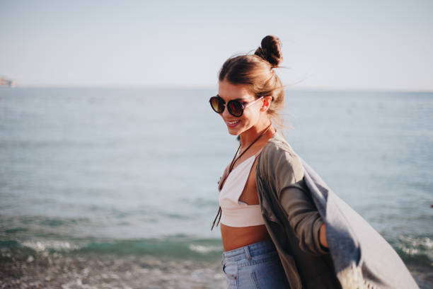 istock Millennial girl with blanket  by the beach 940712154