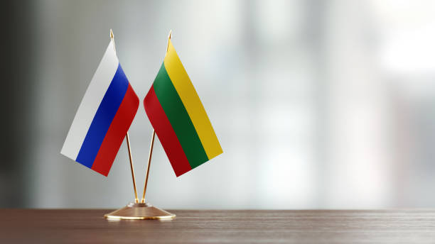 istock Russian And Lithuanian Flag Pair On A Desk Over Defocused Background 940712164