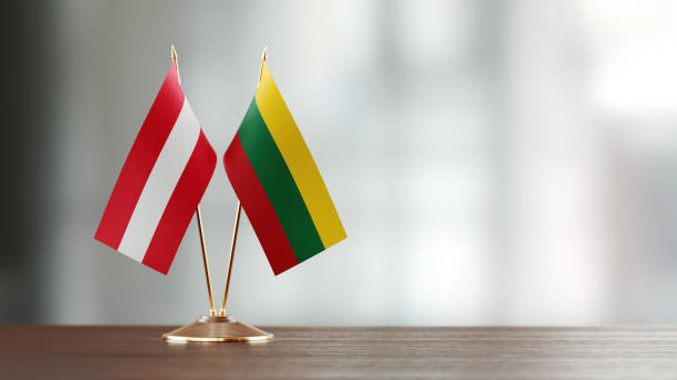 istock Austrian And Lithuanian Flag Pair On A Desk Over Defocused Background 940712260