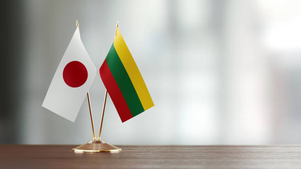 istock Japanese And Lithuanian Flag Pair On A Desk Over Defocused Background 940712828
