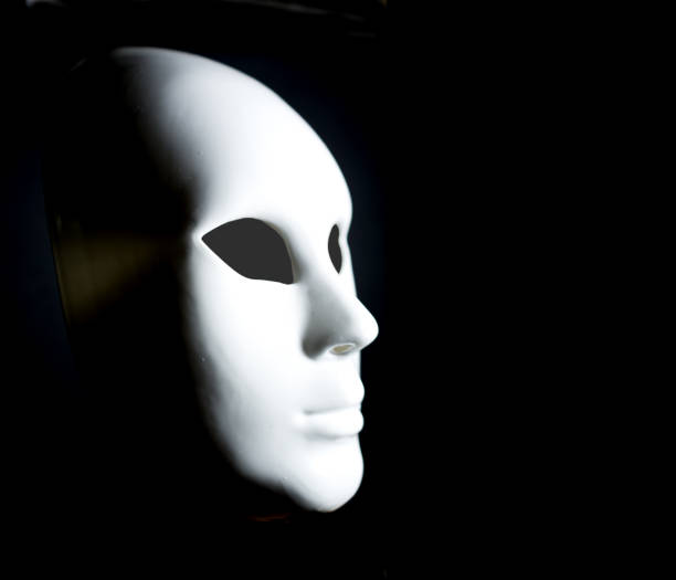 istock White mask of man's face on black background 940716190