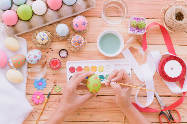 istock Happy easter! A woman hand painting Easter eggs. Happy family preparing for Easter. 940719850