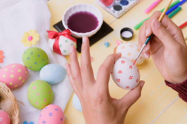 istock Happy easter! A woman hand painting Easter eggs. Happy family preparing for Easter. 940719968