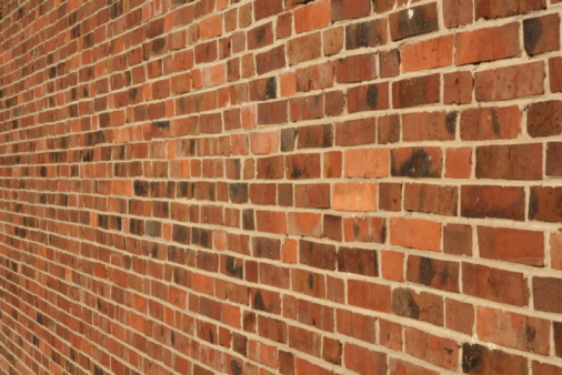 A large area of off-white, light beige painted brick wall surface.