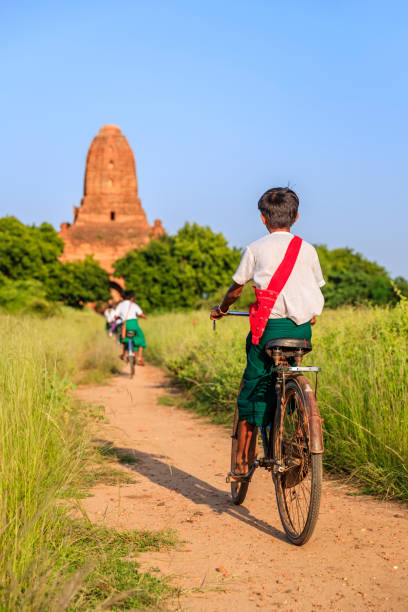 istock Burmese school children riding a bicycle in Bagan, Myanmar 940753438
