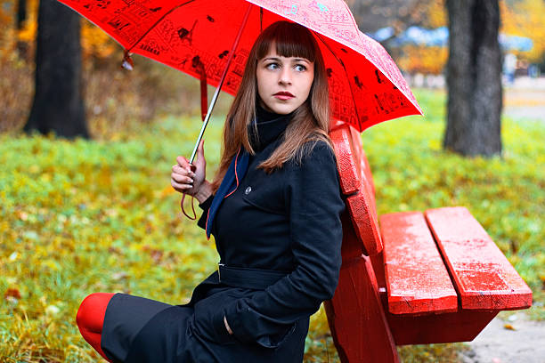 female with umbrella in the park stock photo