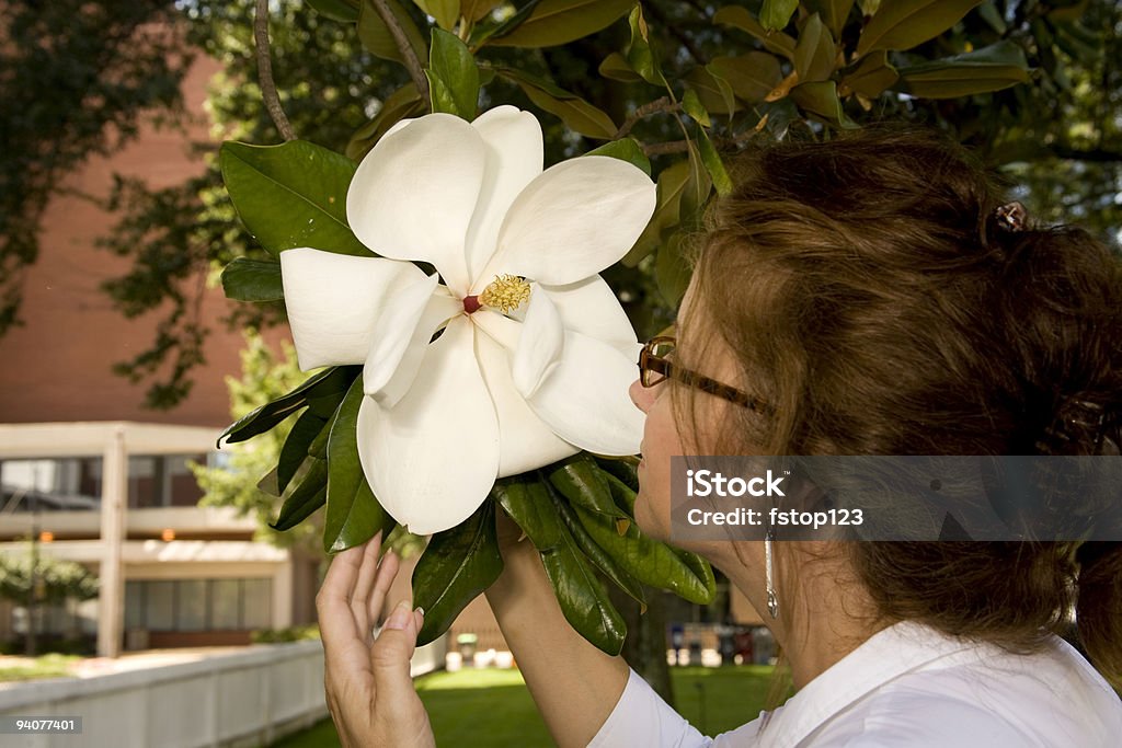 American beauty Magnolia Bloom Lovely woman enjoying a large magnolia bloom. 30-39 Years Stock Photo