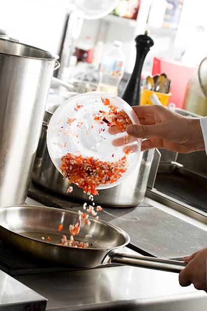 istock Chefs hands add vegetables on frying pan 94078379