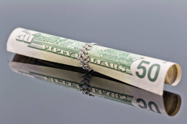 istock fifty dollar bill is rolled into elegant women's silver ring 940791410
