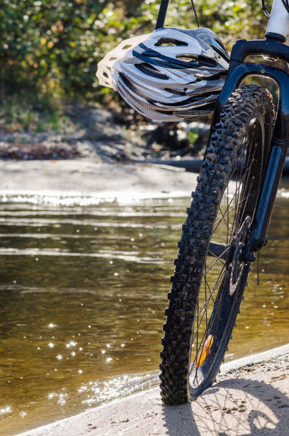 istock bicycle wheel with helmet on river bank background 940818308