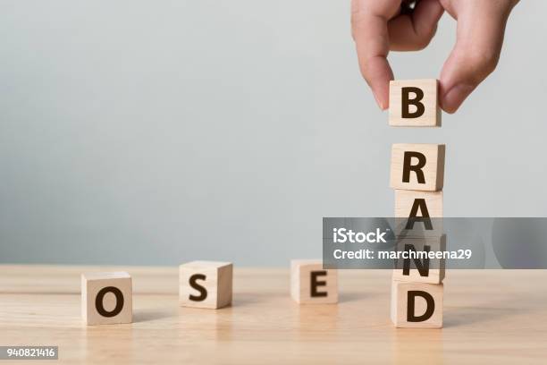 Hand Of Male Putting Wood Cube Block With Word Brand On Wooden Table Brand Building For Success Concept Stock Photo - Download Image Now