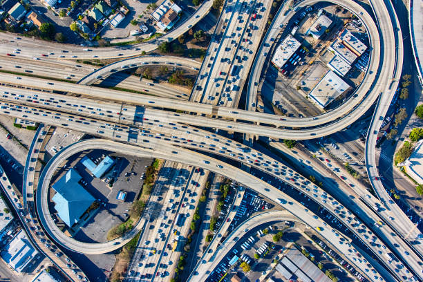 Busy Los Angeles Freeway Interchange Aerial The heavy traffic on the interchange between the Interstate 10 and 110 freeways near downtown Los Angeles, California during rush hour. los angeles traffic jam stock pictures, royalty-free photos & images