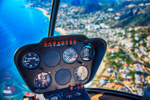 The instrument panel of a helicopter in flight over the Orange County California coastline.