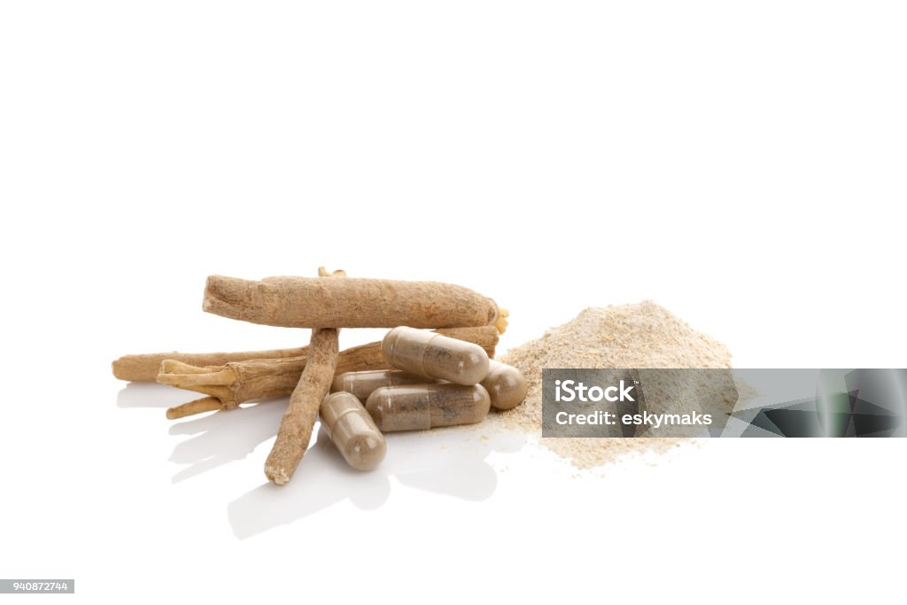 Ashwagandha superfood remedy. Ashwagandha powder with roots and gel capsules. Isolated on white. Superfood adaptogen. Natural remedy. Ashwagandha Stock Photo