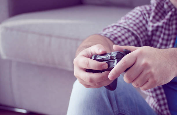 istock a young man with joystick playing video games at home 940876598